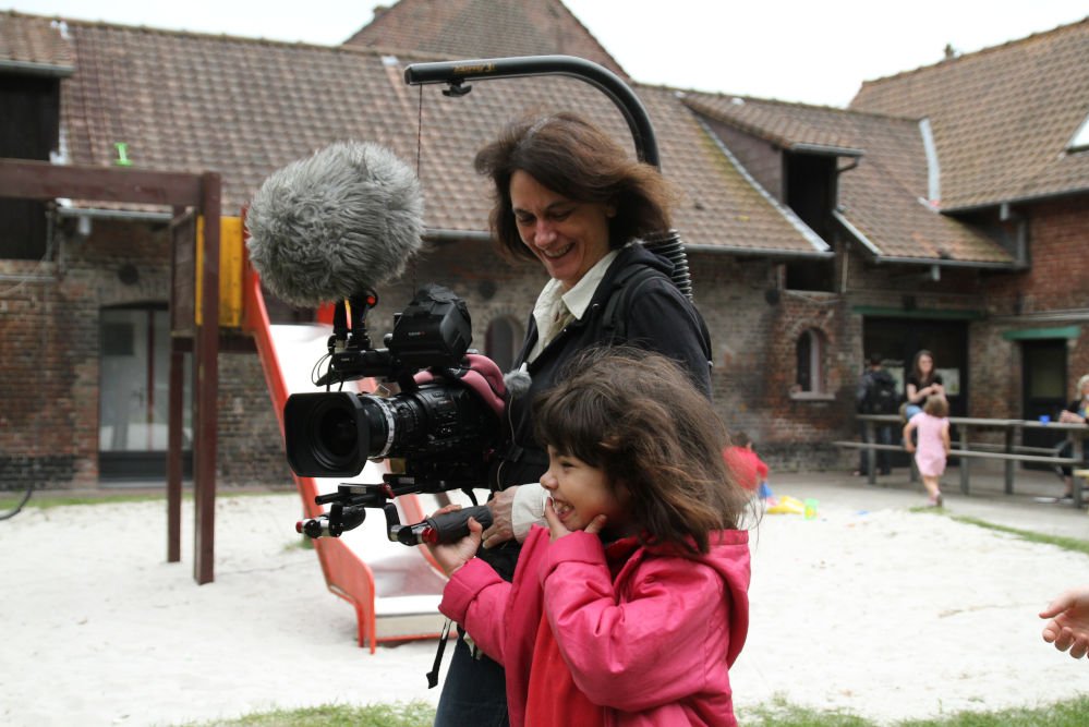 La cinéaste Mariana Otero en compagnie d'une fillette qui l'aide à porter sa caméra