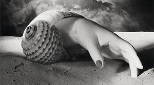 Cette photographie surréaliste de Dora Maar présente un photomontage énigmatique où une main féminine en plâtre, élégamment posée sur du sable clair, se fond avec la forme spiralée d’un grand coquillage. L’objet hybride semble émerger d’un rêve ou d’un désert onirique, sa surface lisse contrastant avec la texture granuleuse du sable. En arrière-plan, un ciel dramatique et tourmenté, probablement inversé ou manipulé, donne l’illusion d’un monde flottant ou d’un paysage sous-marin transformé. L’éclairage sculptural crée des ombres nettes et souligne la composition comme une scène de théâtre figée dans un moment d’étrangeté. L’image incarne pleinement l’esthétique surréaliste chère à Dora Maar, mêlant poésie visuelle, ambiguïté organique et symbolisme latent.