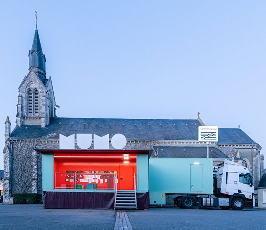 Vue du camion sur une place de village la nuit