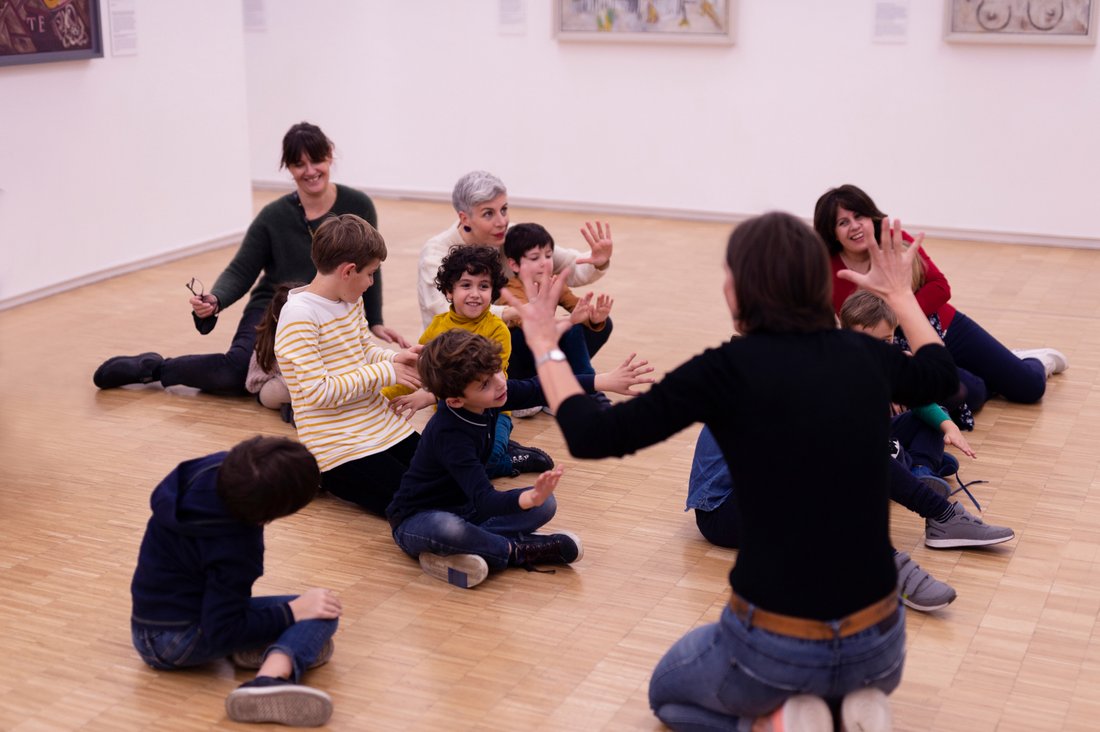 Enfants et parents en cercle dans le Musée